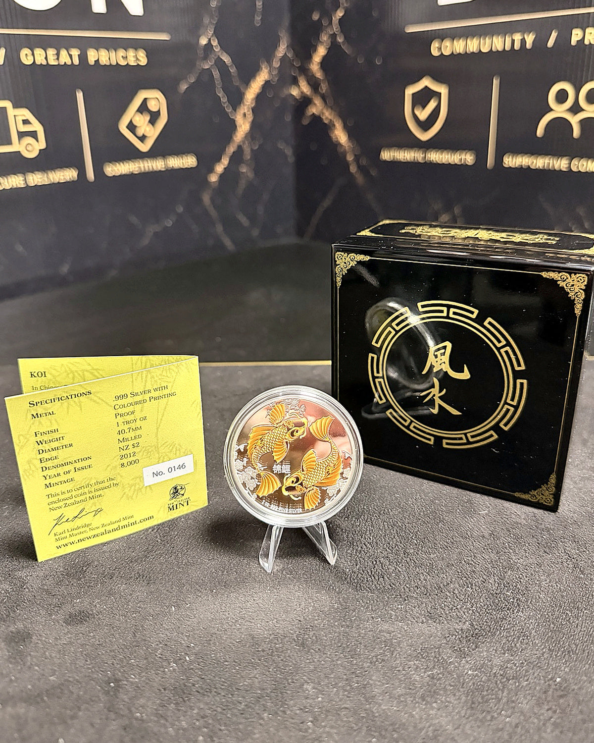 Feng Shui Koi silver colour proof coin beside complete original packaging and COA